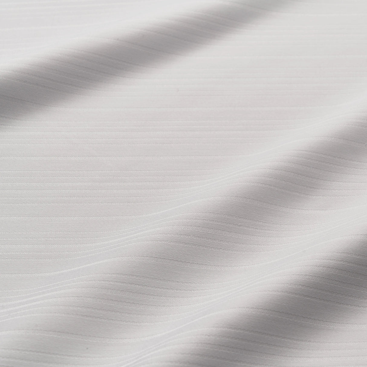 Detailaufnahme des Stoffes - edle, weiße Hotelbettwäsche mit feinem Streifenmuster von Velvetana