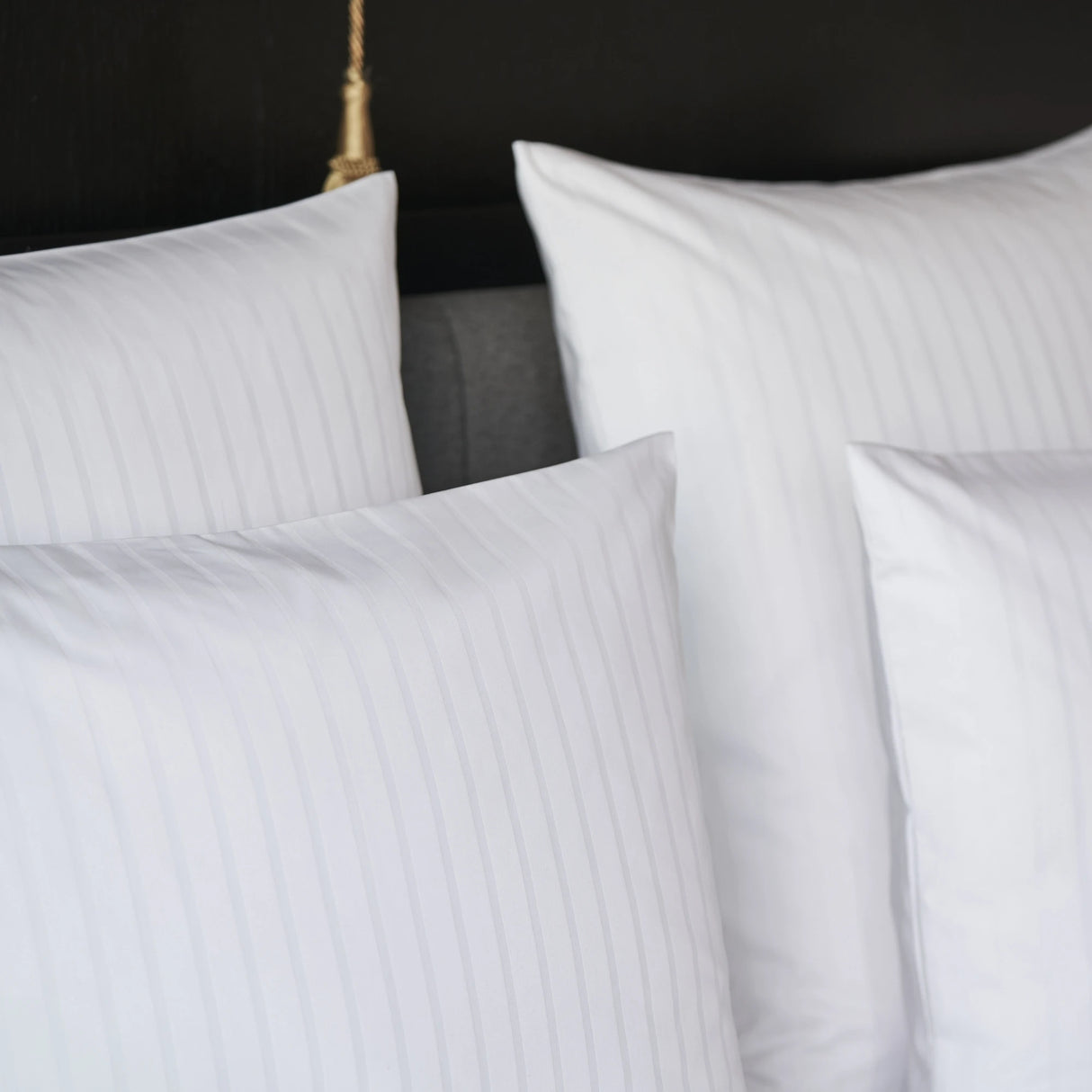 Nahaufnahme eines aufgebetteten Kissens mit Bettbezug Sound - edles Design mit dezenter Streifenstrukur