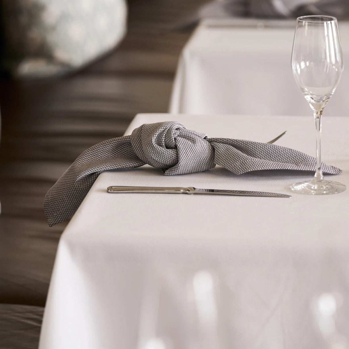 Stilvolle Mahogany-Serviette auf weißer Tischdecke - kreative, elegante Tischdekoration