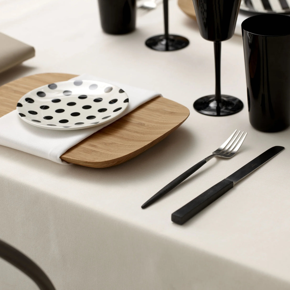 Modern gedeckter Tisch mit schwarzen Akzenten & cremefarbener Tischwäsche bei Velvetana