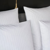 Nahaufnahme eines aufgebetteten Kissens mit Bettbezug Sound - edles Design mit dezenter Streifenstrukur