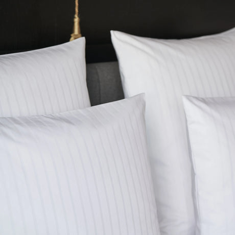 Nahaufnahme eines aufgebetteten Kissens mit Bettbezug Sound - edles Design mit dezenter Streifenstrukur