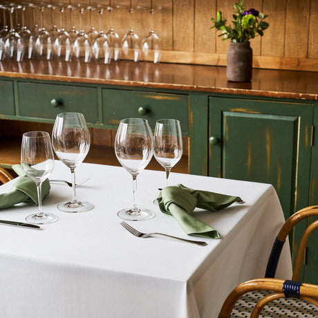Weiße Tischdecke Asti kombiniert mit grüner Stoffserviette - stilvolle Farbkombination bei Velvetana