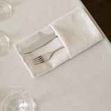 Gefaltete Bestecktasche aus beiger Serviette - stilvolle, hochwertige Tischdekoration