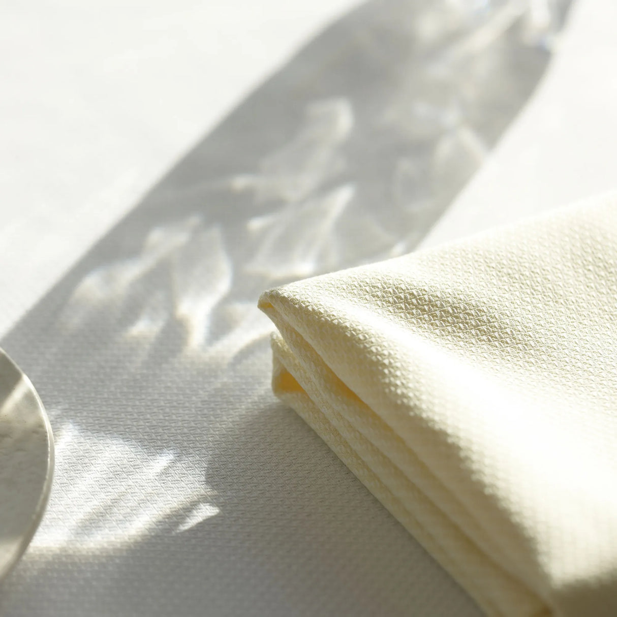 Gelbe Serviette mit weißer Tischdecke - erfrischende, moderne Farbkombination für Hotelrestaurants