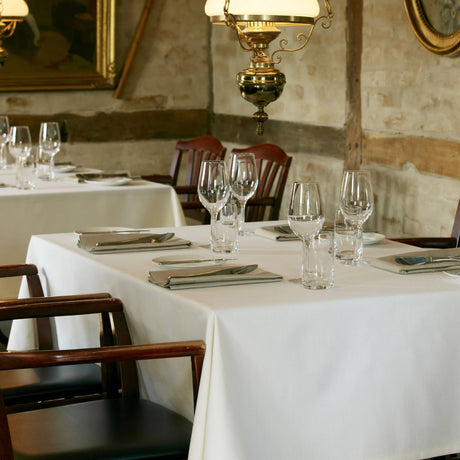 Gedeckter Tisch mit beigefarbenen Servietten - warme, stilvolle Tischdekoration für gehobene Gastro