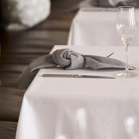 Stilvolle Mahogany-Serviette auf weißer Tischdecke - kreative, elegante Tischdekoration