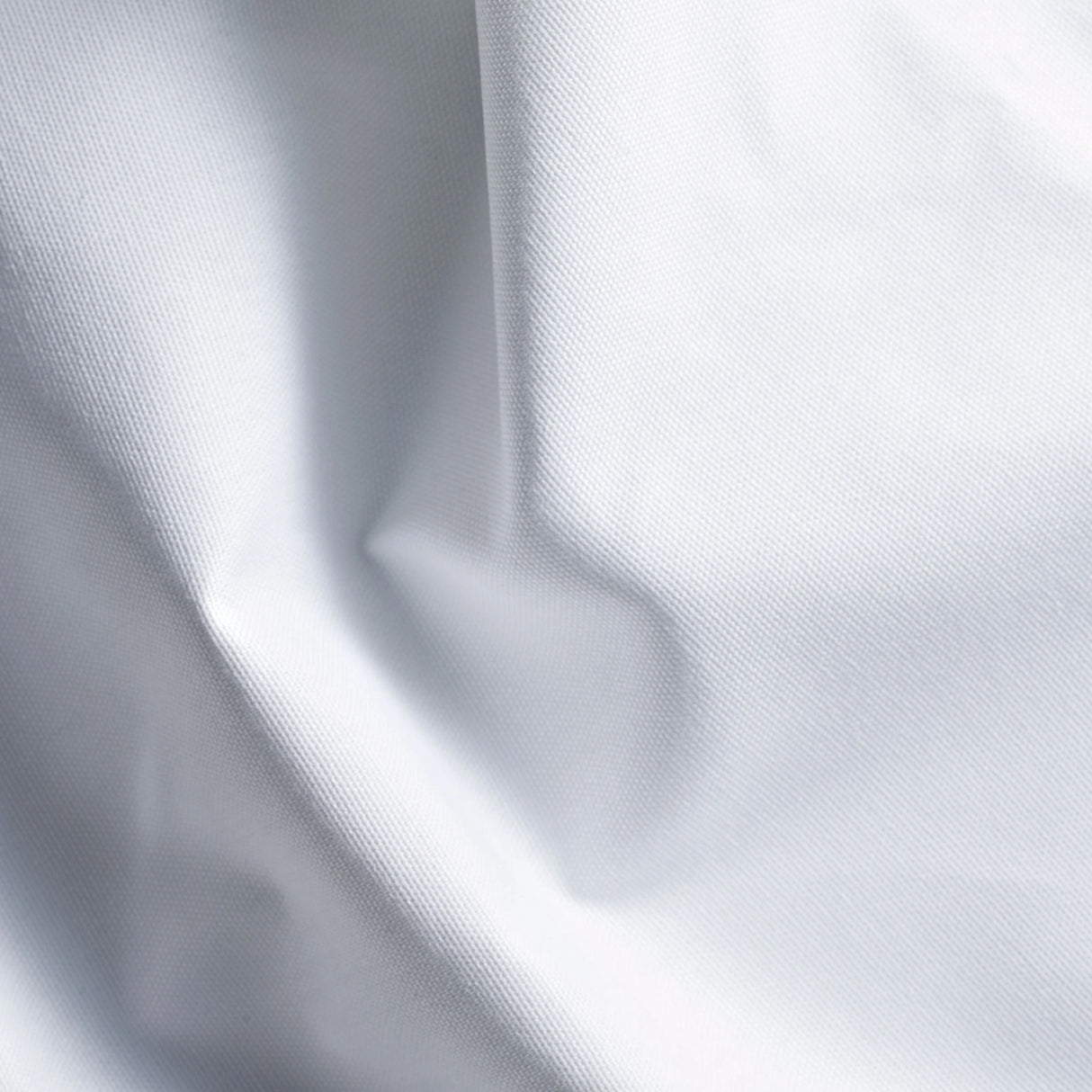 Detailaufnahme des weißen Stoffs - hochwertige, langlebige Tischwäsche mit dezenter Eleganz